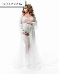 White maternity gown with an embroidered bodice, sheer long sleeves, empire waist, and softly gathered skirt.