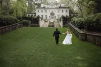 bride and groom strolling across the Sawn House lawn in Atlanta GA