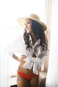 Woman in a white button-down and sun hat during a bright, airy boudoir session in Norfolk, VA