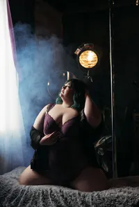 Curvy woman in purple lingerie in smoky studio light, Hampton Roads plus-size boudoir