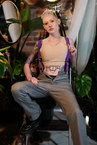 Tattooed client in an alternative, androgynous boudoir session among plants, Norfolk, VA