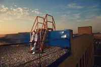 Editorial senior pictures of a teen in a structured blazer on a Minneapolis rooftop at sunset by Megan Engeseth Photography