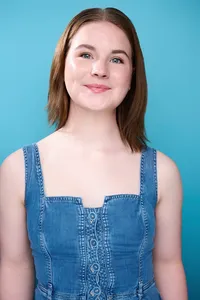 Bright smiling actor on blue backdrop for commercial casting agents