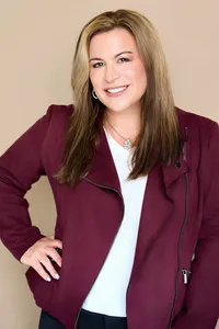 Professional business headshot with neutral backdrop for branding use