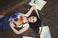Senior portrait of a painting artist surrounded by oil and acrylic artwork in Minneapolis studio
