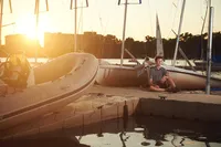 Senior posing with boat on a dock in a lake in Minneapolis MN