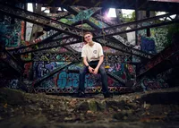 Moody editorial senior portrait of a teen in a trench coat on a rainy Minneapolis street by Megan Engeseth Photography