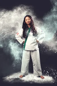 martial arts senior photo with teen wearing white and dust flying