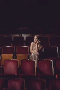 Fine art senior portrait with intentional styling and dramatic composition in a theatre