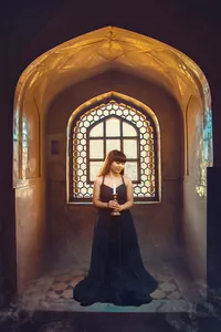 Unique senior portrait in a church with a candle and stained glass