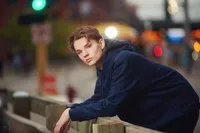 Urban editorial senior pictures of a Twin Cities teen in a structured coat near a glass building by Megan Engeseth Photography