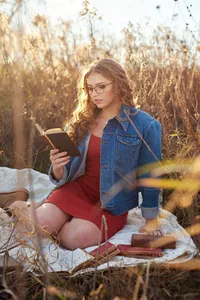 Outdoor senior portrait in a natural meadow setting with warm light and relaxed expression