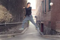 High School Senior jumping to kick soccer ball in alley in Minneapolis