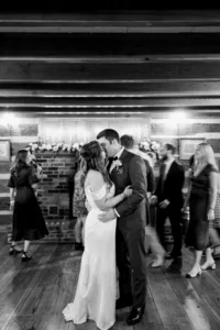 Couple sharing an intimate dance surrounded by guests at a wedding reception.