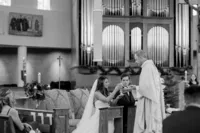 Bride and groom receiving wedding rings during a church ceremony.