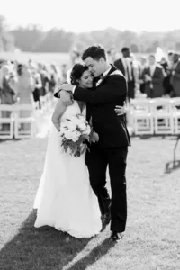 Bride and groom embracing outdoors after their wedding ceremony.