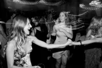 Women dancing and enjoying themselves at a party with motion blur effects from the lighting.