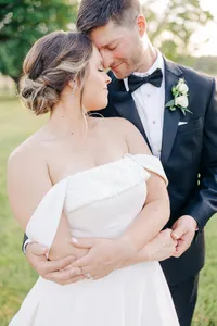 A bride and groom share an intimate moment together outdoors.