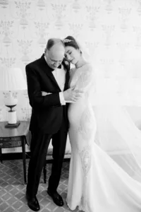 A tender moment between a bride and an older gentleman, likely a family member, captured in a black-and-white photograph.