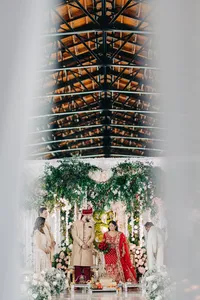 Couple dressed in traditional attire at a lavish wedding ceremony.