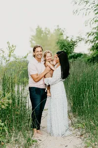 family together on the beach in tall grass