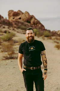 Smiling team portrait of videographer captured by elopement planner
