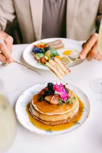 Guest served pancakes and eggs at a garden brunch table