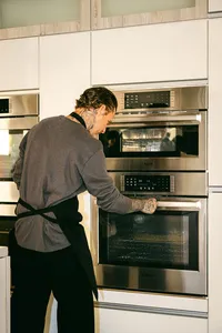 Michael Voltaggio setting a Bosch wall oven mid-competition