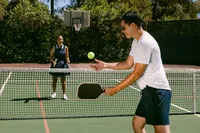 Two players mid-rally on a backyard pickleball court