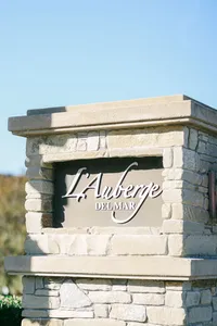 Stone L’Auberge Del Mar entrance sign under a clear blue sky in Del Mar, California, luxury resort property photography