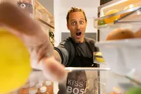 Chef Michael Voltaggio reaching into a Bosch refrigerator, caught mid-reaction