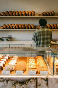 Loaves lining the shelves of a Monterey bread bakery, a customer at the counter