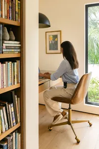 Woman working at a desk in a sunlit home office