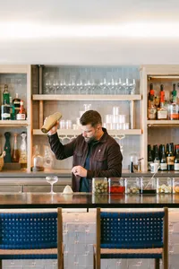 Bartender shaking a cocktail behind the back bar at Monterey Beach Hotel