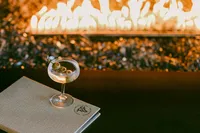 Martini resting on a linen menu beside an open fire