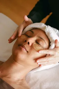 Guest relaxing during a facial with gold under-eye masks at Spa L’Auberge in Del Mar, luxury hotel spa photography