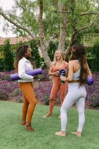 Three guests carrying mats to a Spa Estancia yoga session on the lawn