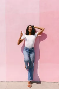 Commercial lifestyle brand photography featuring a model using a skincare product for a fresh, modern beauty campaign