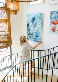 Personal brand photography of a mixed media artist installing artwork in her home studio in Southern California.