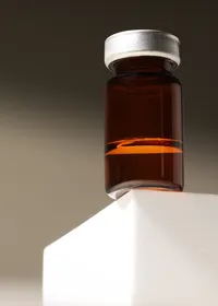 Single amber jar on a white plinth, studio product still