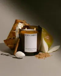 Directional light and soft shadow fall across a Soft Current Pearfection candle styled with pear pastry, a spoonful of mascarpone, cinnamon, and pear slices. Editorial still life by Chelsea Loren.