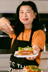 Mei Lin holding out a finished sandwich plate to camera