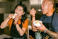 Chefs Mei Lin and Jet Tila tasting each other's dishes mid-competition
