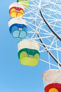 Chelsea Loren branding travel tourism photographer capturing Luna Park ferris wheel colorful baskets in the sky on a blue backdrop in Sydney, Australia