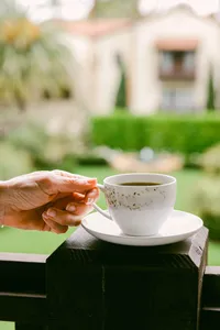 Coffee service handed across a ledge overlooking the hacienda courtyard