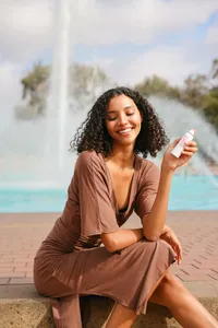 Commercial lifestyle brand photography featuring a model holding a skincare product for a fresh, modern beauty campaign