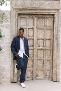 Navy linen set against carved wooden doors and stone