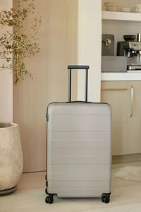 Large MUJI suitcase photographed in a naturally lit kitchen interior