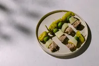 Basque-inspired pintxos with Natural Catch mackerel, guindilla peppers, olives, and manchego in dappled sunlight