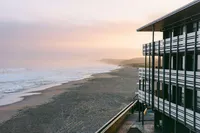 Monterey Beach Hotel's oceanfront exterior above the shoreline at dusk